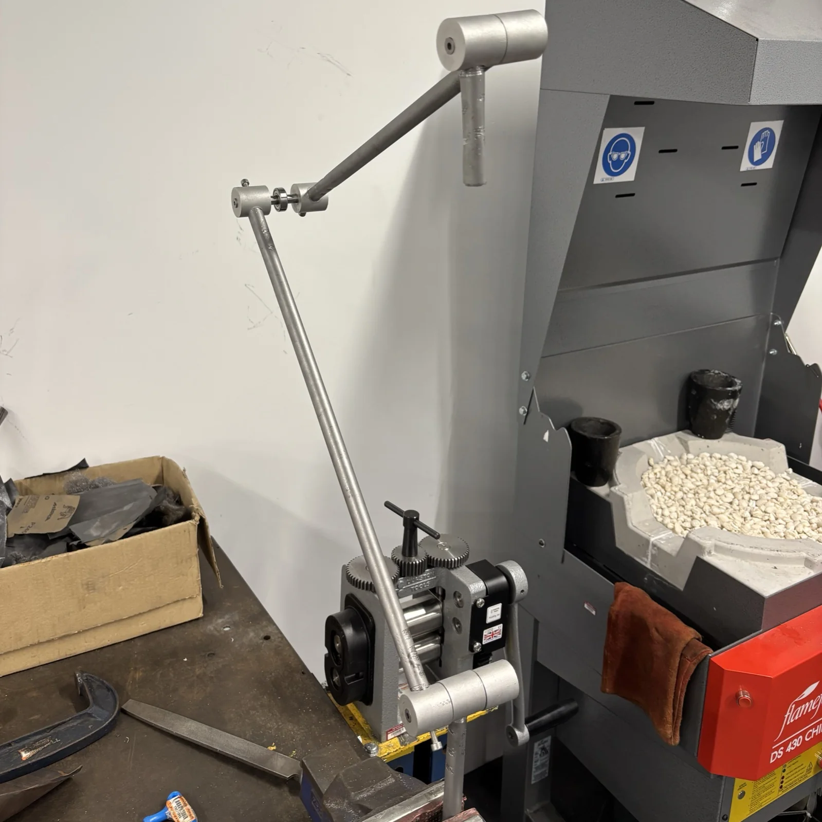 The lamp arm being shaped on a metal roller in the workshop